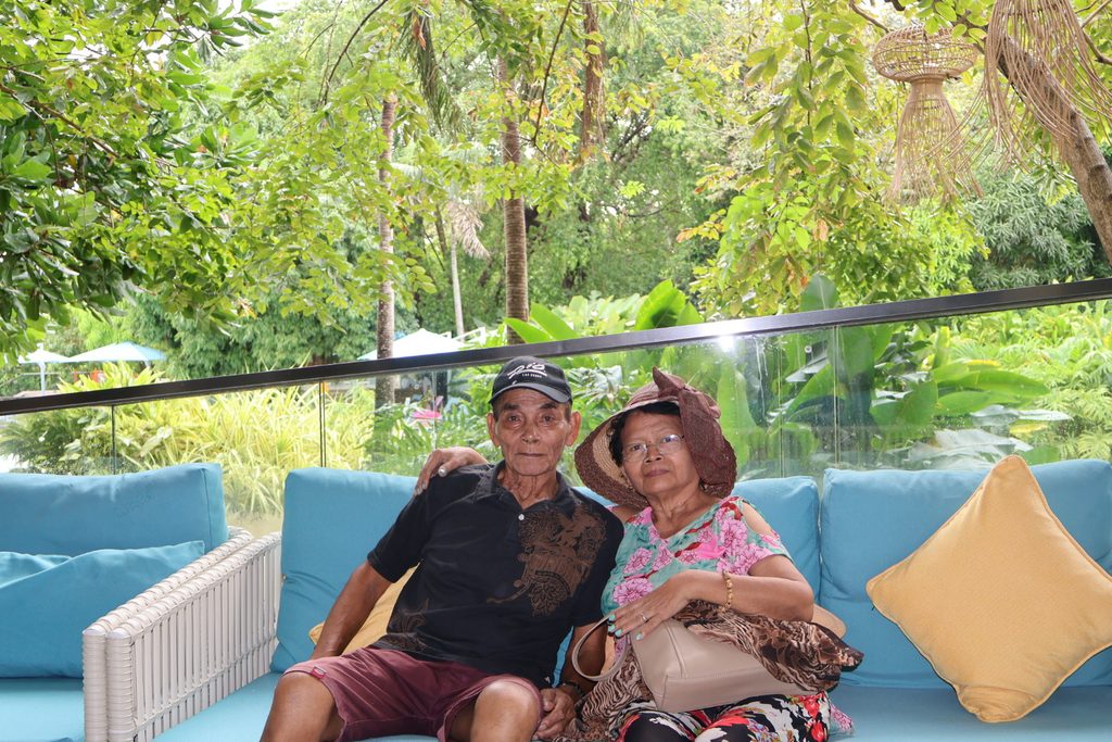 Grandparents relaxing together on an outdoor sofa